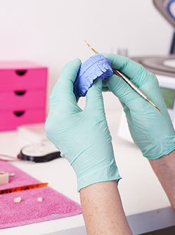 Gros plan sur les mains d'un épithésiste réalisant une prothèse - MACSF