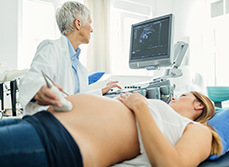 Une femme médecin procède à un examen échographique sur une patiente enceinte - MACSF