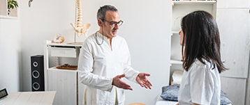 Un kinésithérapeute apporte des explications à une patiente - MACSF