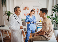 Un médecin discute avec un patient adolescent pendant qu'une infirmière prend des notes - MACSF