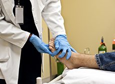 Un médecin auscule le pied d'un homme - MACSF