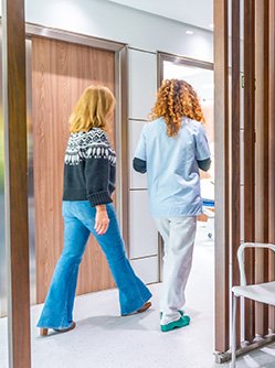 Une infirmière et une patiente dans un couloir - MACSF