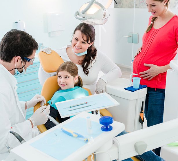 Dentiste en consultation avec une jeune patiente accompagnée de sa mère enceinte - MACSF
