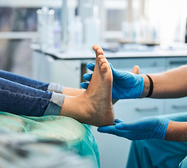 Un podologue examine les pieds d'un patient - MACSF