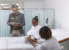 Un médecin prend des notes auprès d'une jeune patiente et de sa mère à l'hôpital - MACSF