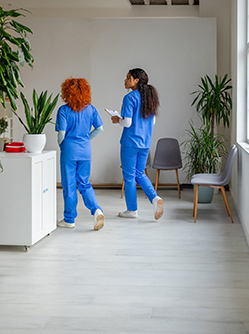 2 infirmières de dos dans le couloir d'un établissement de santé - MACSF