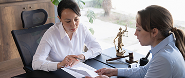 Deux femmes échangent sur un document - MACSF