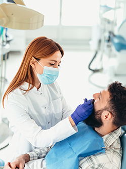 Une dentiste examine les dents des son patient - MACSF