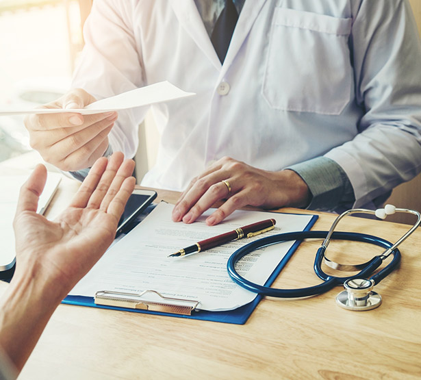 Un médecin remet un document à une patiente - MACSF