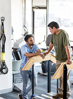 Des kinés discutent avec des patients dans une salle de rééducation - MACSF