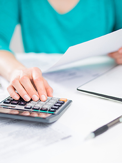 Une main de femme utilisant une calculatrice, en train de saisir ou vérifier des chiffres - MACSF