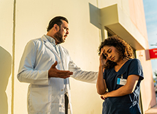 Médecin en colère parlant à une infirmière devant l’hôpital - MACSF