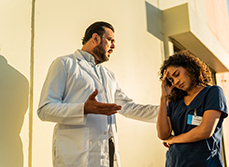 Médecin en colère parlant à une infirmière devant l’hôpital - MACSF