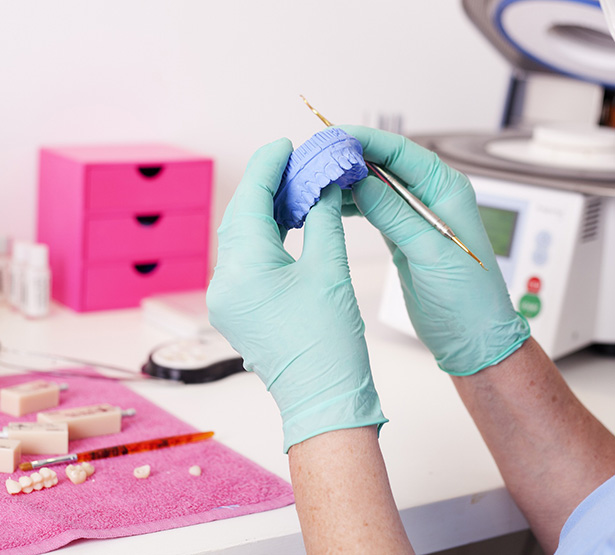 Gros plan sur les mains d'un épithésiste réalisant une prothèse - MACSF