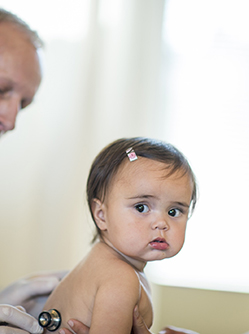Un médecin ausculte une petite patiente auprès de sa maman - MACSF