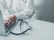 Un stéthoscope posé sur un ordinateur portable utilisé par un professionnel de santé, avec des icônes médicales numériques en surimpression - MACSF