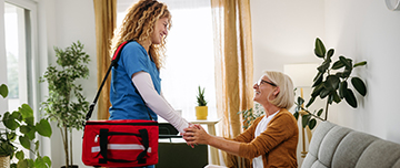 Une infirmière à domicile serre la main de la patiente - MACSF