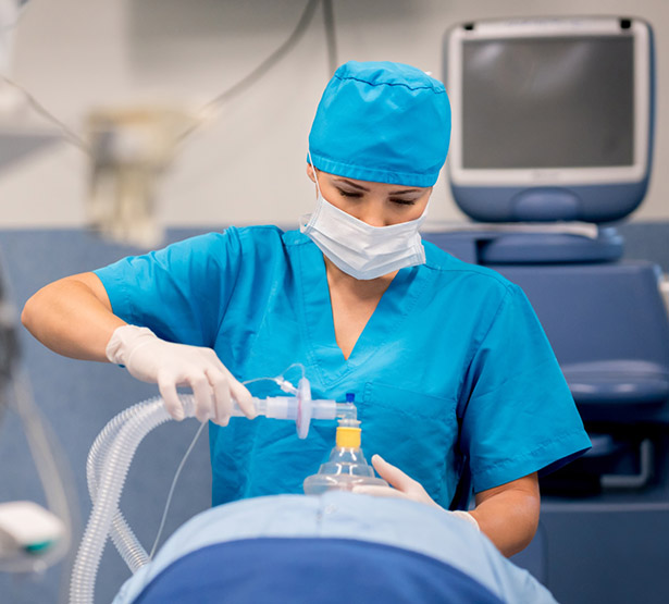 Une IADE applique un masque d'anesthésie sur un patient au bloc - MACSF