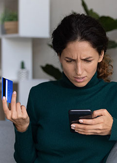 une femme consulte sont téléphone et constate une fraude à sa carte bancaire | MACSF