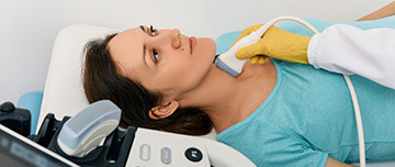 Le radiologue effectue une échographie de la thyroïde sur une femme - MACSF