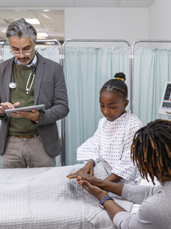 Un médecin prend des notes auprès d'une jeune patiente et de sa mère à l'hôpital - MACSF