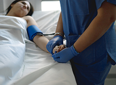 Une infirmière prend la tension d'une patiente alitée à l'hôpital - MACSF