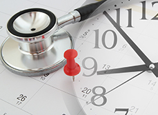 Un stéthoscope posé sur un agenda marqué d'une punaise rouge - MACSF