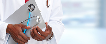 Gros plan sur les mains d'un médecin tenant un stéthoscope et un fichier - MACSF