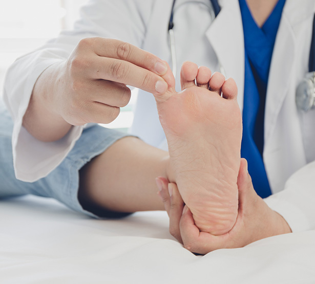 Le médecin ausculte le pied d'une patiente - MACSF