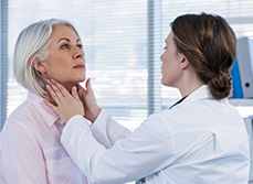 Une femme médecin examine le cou d'une patiente - MACSF