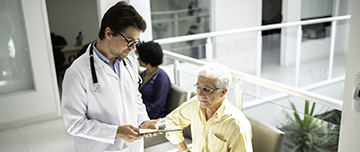 Un médecin discute avec un patient dans la salle d'attente de l'hôpital - MACSF