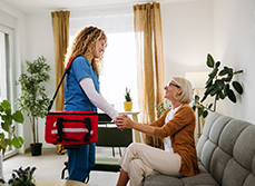Une infirmière à domicile serre la main de la patiente - MACSF