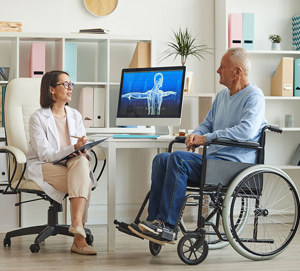 Une femme médecin en consultation avec une homme en fauteuil roulant - MACSF