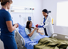 Une élève sage-femme donne un médicament à une parturiente - MACSF