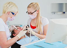 Un chirurgien-dentiste et son assistante dentaire pratiquent des soins sur un patient - MACSF
