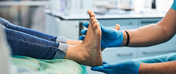Un podologue examine les pieds d'un patient - MACSF