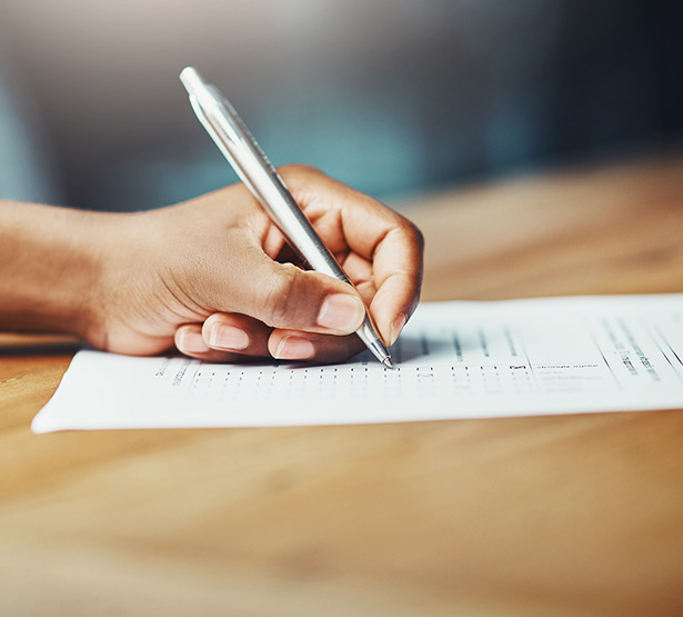 Main d'une personne écrivant sur un document - MACSF