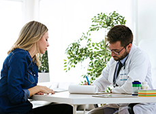 Un médecin prend des notes pendant sa consultation avec une patiente - MACSF