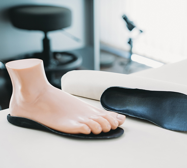 Un pied mannequin posé sur une semelle orthopédique noire - MACSF
