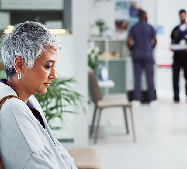 Une femme pensive à l'air triste assise dans le couloir à l'hôpital - MACSF