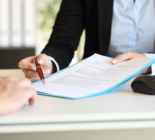 Personne tenant un stylo et présentant un contrat de travail à signer - MACSF