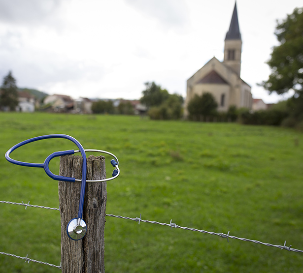 Un stéthoscope posé sur le poteau d'un pré avec la campagne en arrière-plan - MACSF
