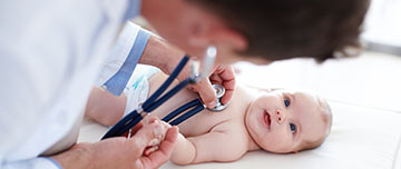 Un pédiatre ausculte un nouveau-né