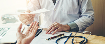 Un médecin remet un document à une patiente - MACSF