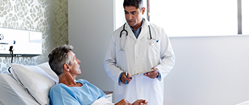 Un médecin écoute un patient alité à l'hôpital - MACSF
