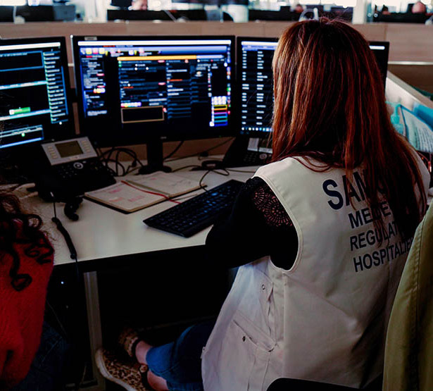 Vue de dos d'une femme médecin devant ses écrans de régulation du SAMU - MACSF