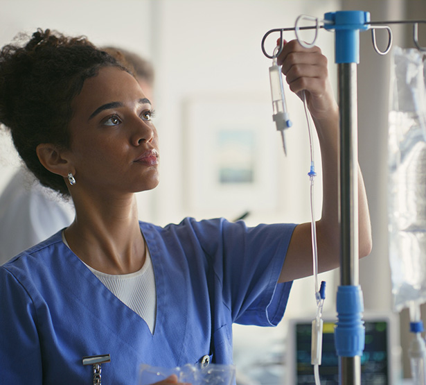 Une infirmière règle le débit d'une perfusion - MACSF