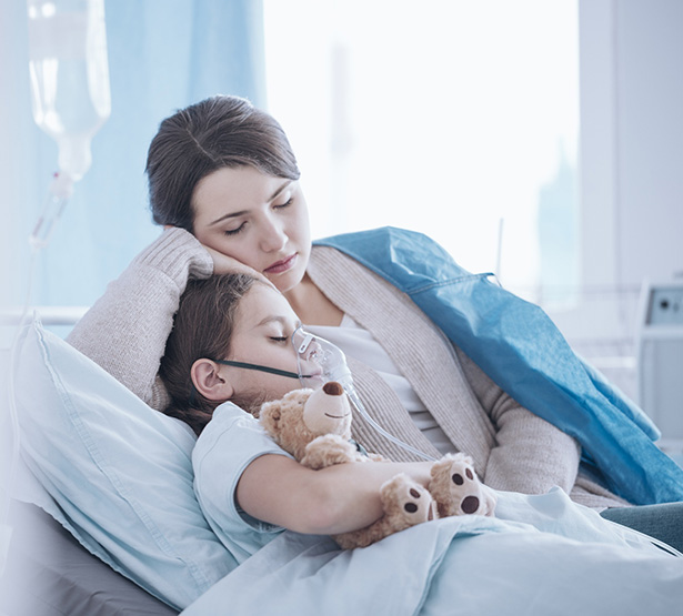 Une maman allongée à côté de son fils sur le lit de l'hôpital - MACSF