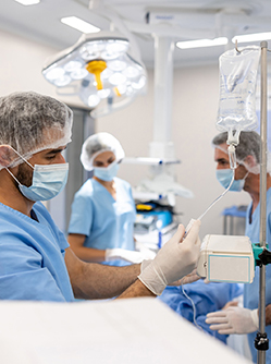 Le médecin règle la perfusion du patient au bloc - macsf