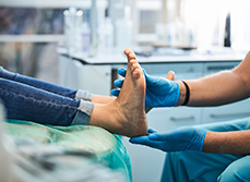 Un podologue examine les pieds d'un patient - MACSF